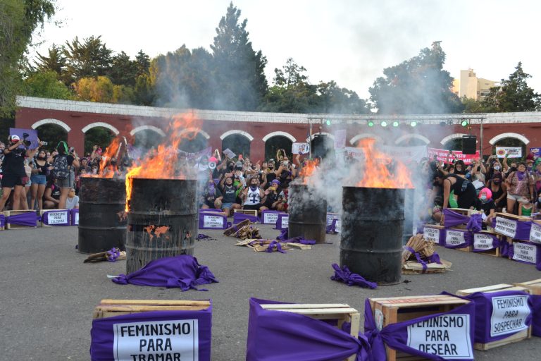Instalación en los arcos romanos, tachos con fuego ardiendo, banderas violetas, multitud de mujeres.